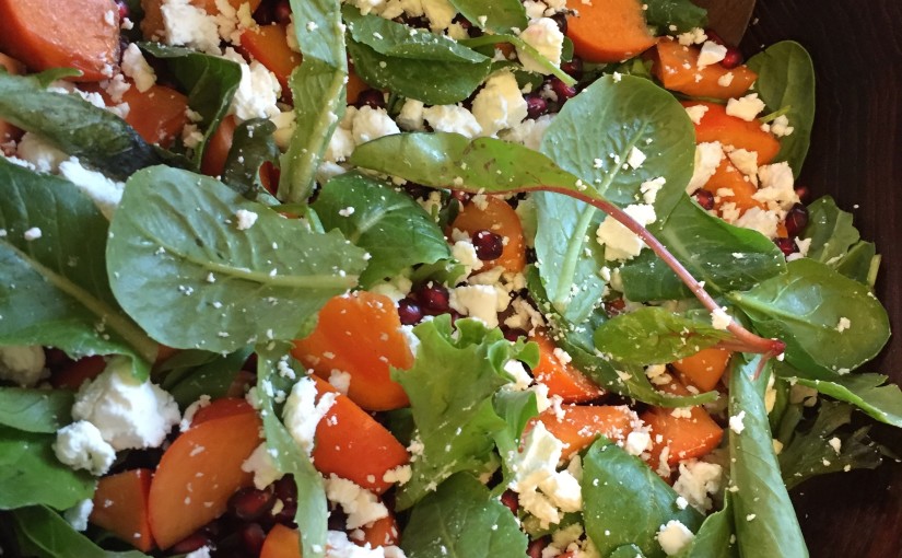 Salad with persimmons, pomegranate and goat cheese